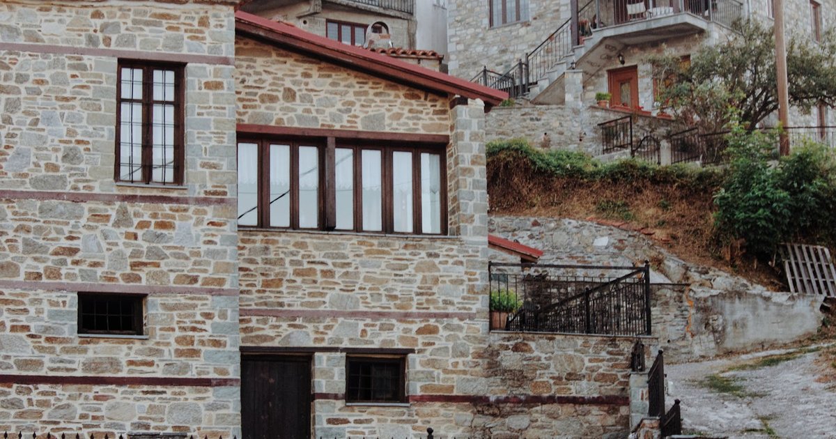 Traditional stone village in the Corfu mountains with olive trees and bell tower