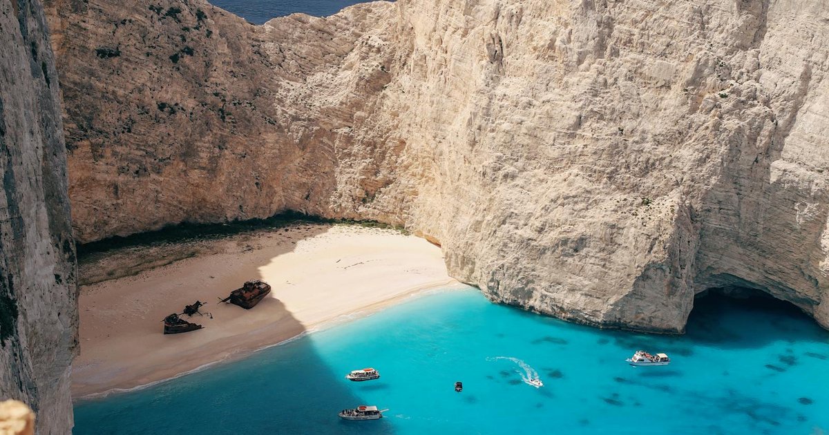 Small boat anchored in turquoise water at a secluded Corfu cove