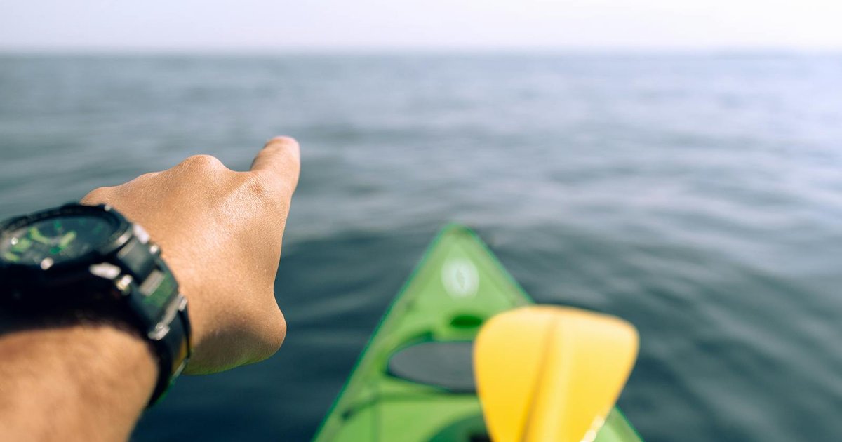 Sea kayaker paddling along Corfu's turquoise coastline
