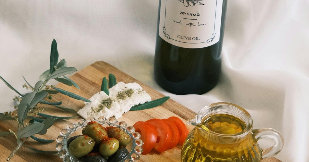 Bottles of Corfu olive oil with fresh bread and olives on a wooden board